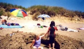 Kids at play near Gypsolithos – there is no tide in the Mediterranean to refill the hole (24/07/01).