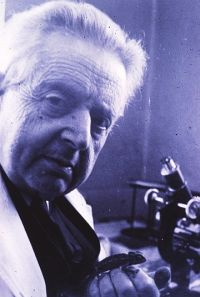 Dr Edward Elkan, photographed in his 80s, with live chameleon and microscope to hand